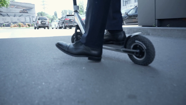 vista recortada de hombre de negocios en el desgaste formal montar patinete scooter cerca de estacionamiento
 - Imágenes, Vídeo