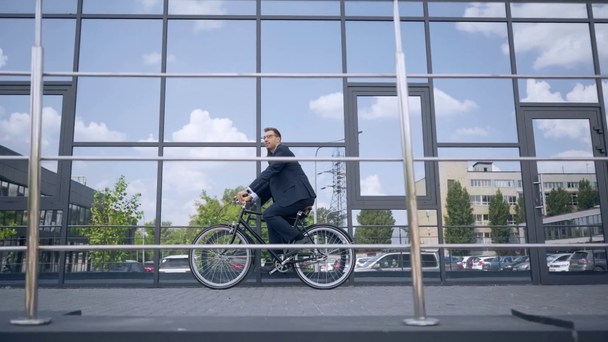 homme d'affaires dans l'usure formelle vélo d'équitation près du bâtiment pendant la journée
 - Séquence, vidéo