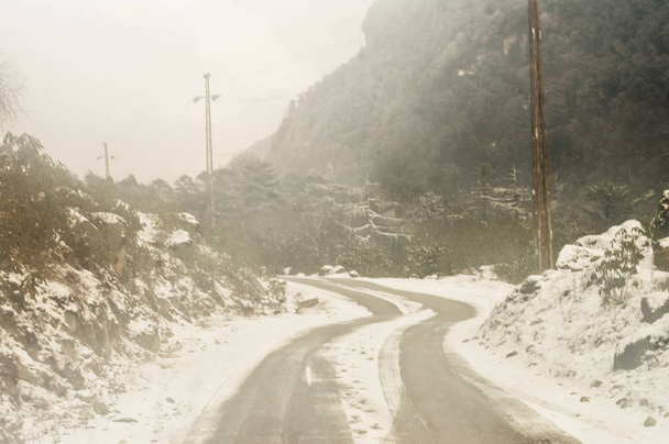 Windy snowy foggy slippery muddy flat step himalayan mountain road in winter. Leh Manali Highway, Jammu and Kashmir, India, Asia. - Fotoğraf, Görsel