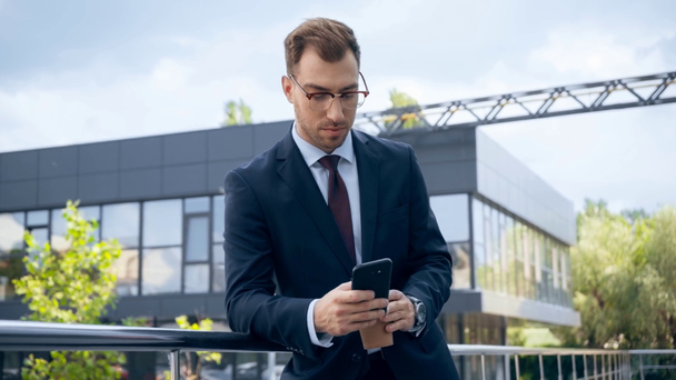 businessman in formal wear using smartphone near building during daytime - Záběry, video