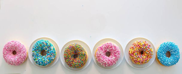 Donut met kleurrijke decoratie op witte kleur achtergrond. Top View - Foto, afbeelding