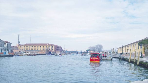 Venice, Italy - 04/24/2019: An amazing panoramic view of Venice in winter days with some Gondolas around the sea and beautiful caption of the buildings with grey sky in the background - Photo, Image
