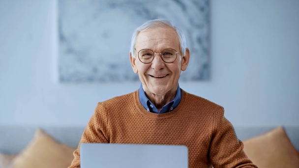 selective focus of happy senior man in glasses laughing while looking at camera  - Video