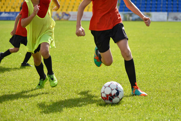 Молодые футболисты играют в футбол на стадионе
 - Фото, изображение