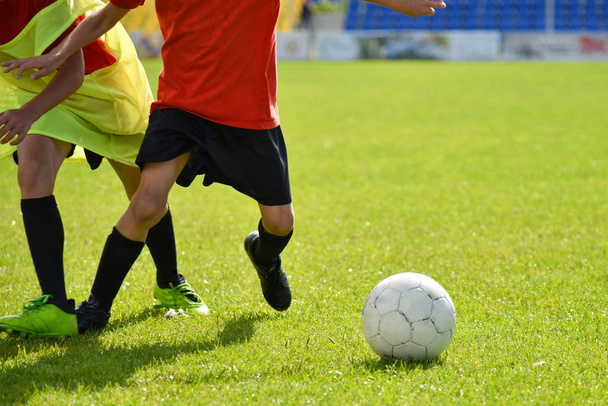 Nuoret jalkapalloilijat pelaavat jalkapalloa stadionilla
 - Valokuva, kuva