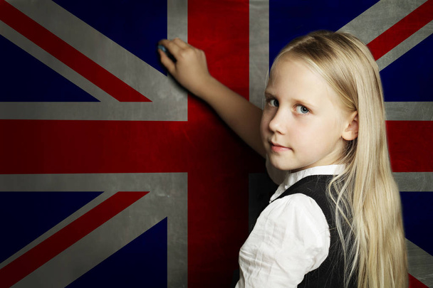 Χαριτωμένο παιδί μαθήτρια εναντίον του Ηνωμένου Βασιλείου σημαία φόντο.  - Φωτογραφία, εικόνα