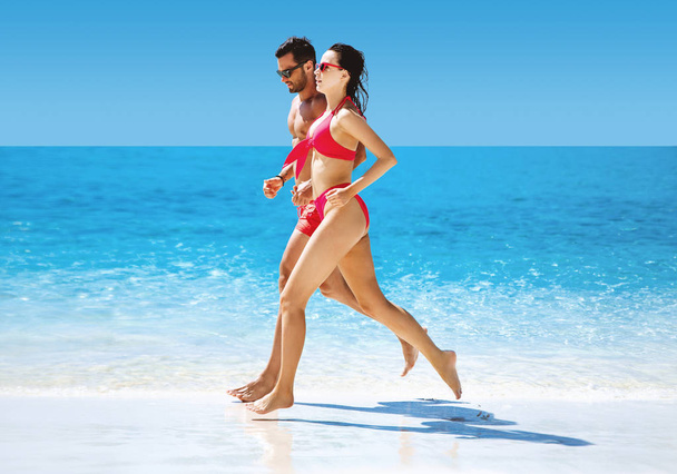 Couple apte à faire du jogging sur une plage tropicale
 - Photo, image