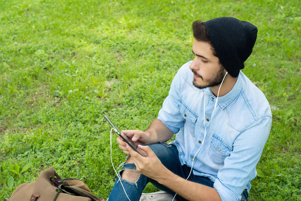 Young latin man using tablet outdoors. - Foto, Imagen