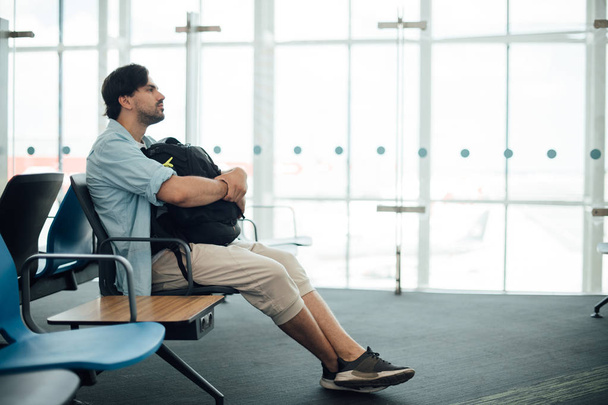 Ο τύπος στο αεροδρόμιο περιμένει την αναχώρηση.. - Φωτογραφία, εικόνα