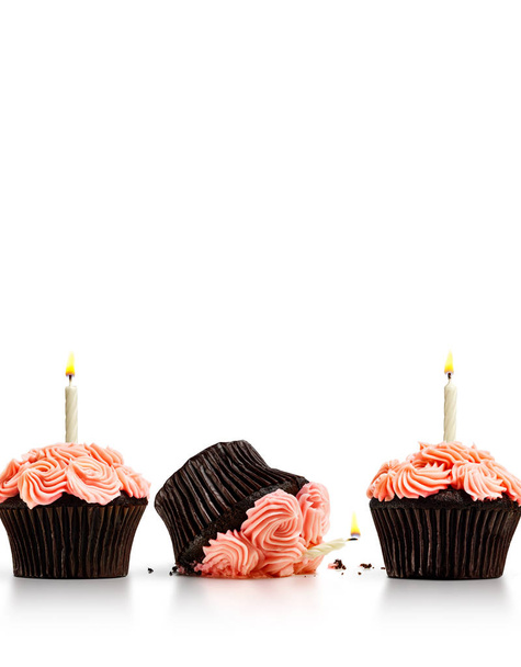 Smashed cupcake in row of cupcakes with candles isolated on whit - Photo, Image