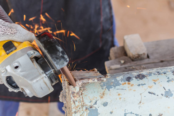 Sparks flying over the working during metal grinding - 写真・画像