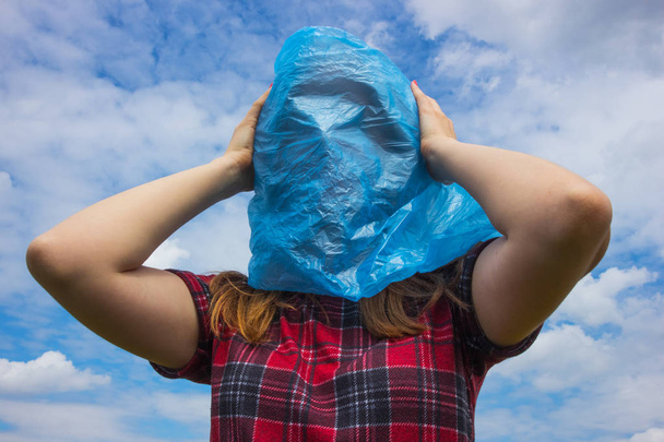 Bolsa de plástico azul en la cabeza humana, concepto de gran problema ecológico. La contaminación ambiental es uno de los problemas más graves. Di no al plástico y salva la Tierra
. - Foto, imagen