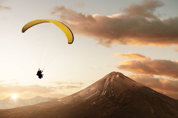 Gele tandem Paraglider geniet van vrijheid in het schilderachtige berglandschap - Foto, afbeelding