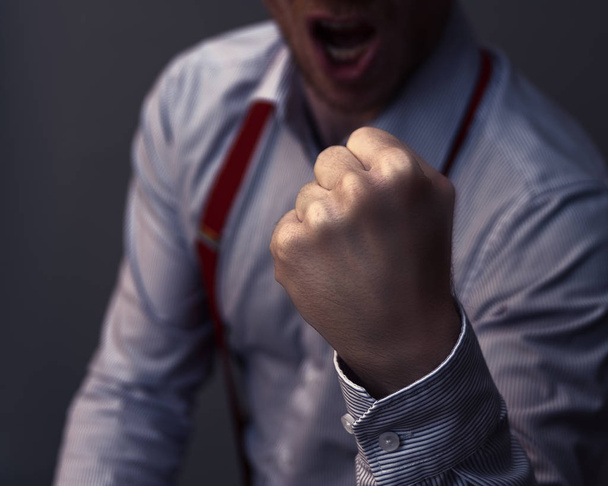 Liikemies puristaa nyrkkiään ja on aggressiivinen tai juhlii menestystään
 - Valokuva, kuva