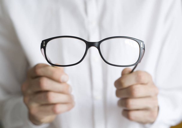 O médico oftalmologista está a segurar óculos. O conceito de problemas de visão. Conceito óptico
.  - Foto, Imagem