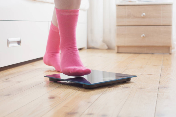 female feet in socks on the floor scales - Fotografie, Obrázek