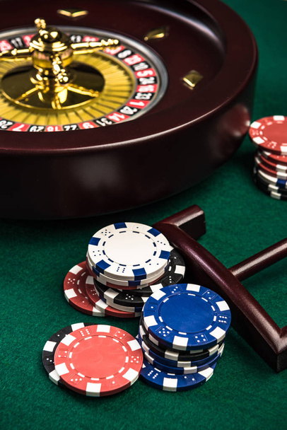 Dřevěná ruleta s Casino chipsy na zelené plsti - Fotografie, Obrázek