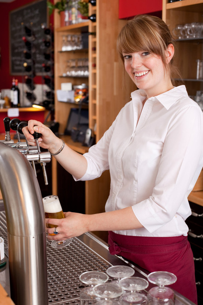 Smiling waitress pouring draft beer - Фото, зображення
