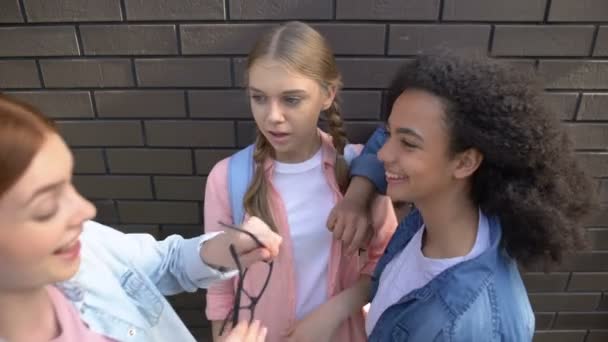 Tieners krijgen school genoot brillen, spottende vrouwelijke leerling, pesten wreedheid - Video