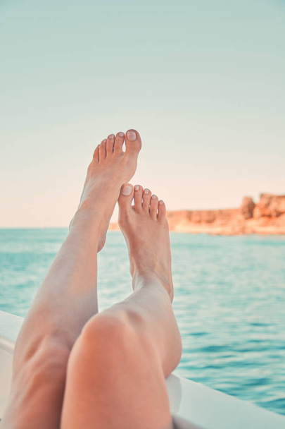 Girl relaxing on the yacht. Womans feet on the yacht. - Photo, Image