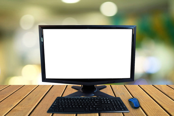 Computer-Desktop-PC mit leerem Bildschirm und Tastatur und drahtloser Maus auf Holzböden mit verschwommenem buntem Bokeh-Hintergrund - Foto, Bild