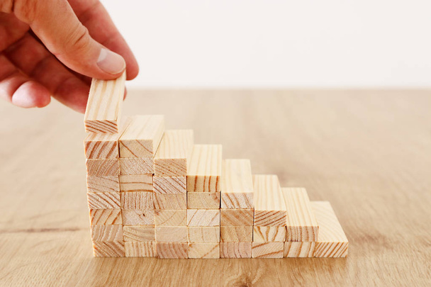 Business image of arranging wood blocks stacking as step stairs. Success and development concept - Фото, изображение