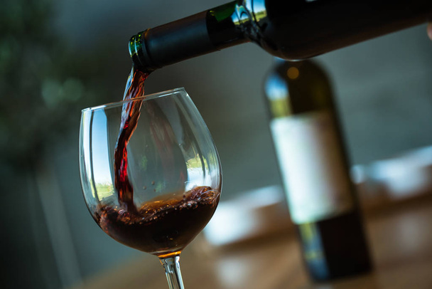 Closeup of pouring red wine, alcohol. - Foto, imagen