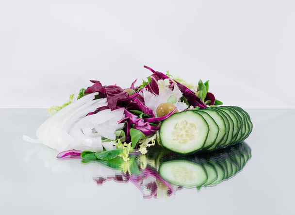 新鮮なトロピカル野菜サラダ - キュウリのスライス、赤キャベツ、オリーブ、ほうれん草、みじん切り玉ねぎ - 写真・画像