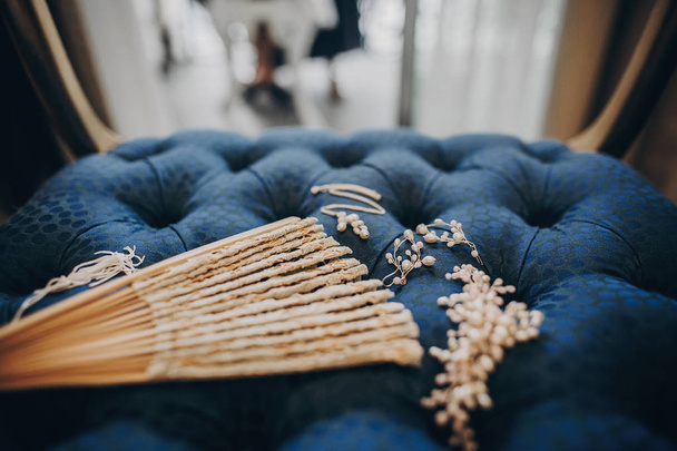Стильные жемчужные серьги, ожерелье, шпилька и винтажный вентилятор на блюзе
 - Фото, изображение