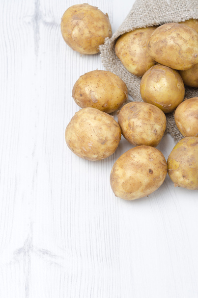 New potatoes in a sack on a white background with space for text - Fotoğraf, Görsel