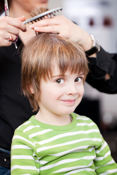 Adorable little boy getting a hair cut - 写真・画像