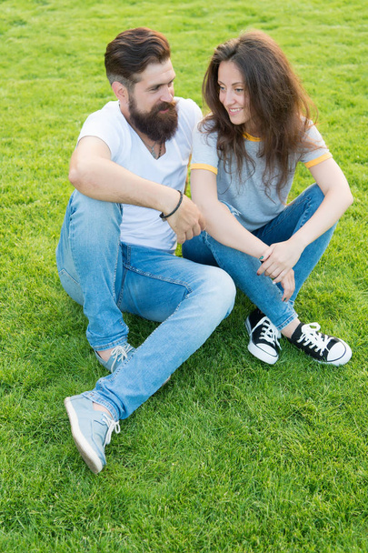 Couple in love relaxing on green lawn. Lovely couple outdoors. Simple happiness. Couple relations goals. Couple spend time in nature. Playful girlfriend and boyfriend dating. Summer vacation - Фото, зображення