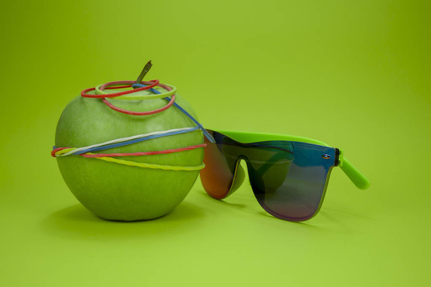 Apple tied in rubber bands and fashion sunglasses - Photo, Image