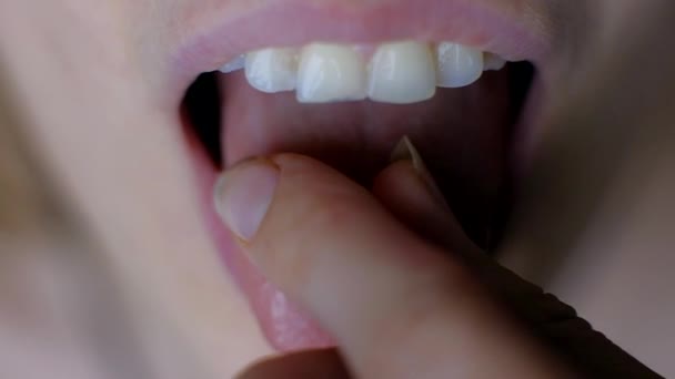 Női kézzel Putting sárga a fogamzásgátló tabletta a nyelvét.  - Felvétel, videó