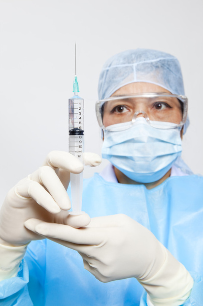 A medical doctor preparing an injection in a syringe - Fotó, kép