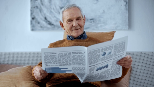ευτυχισμένος συνταξιούχος άνθρωπος κάθεται σε αναπηρικά αμαξίδια και διαβάζοντας το βιβλίο στο σπίτι  - Πλάνα, βίντεο