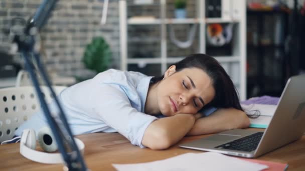 Portrait of young woman sleeping on desk relaxing at work indoors - Video
