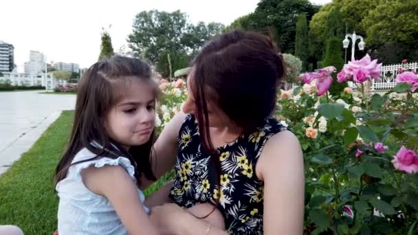 Αργή κίνηση: νεαρή μητέρα προσπαθεί να ευθυμήσει την κόρη της και αγκαλιές στο πάρκο - Πλάνα, βίντεο