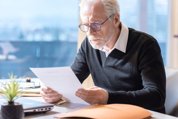Senior businessman reading a document - Foto, imagen