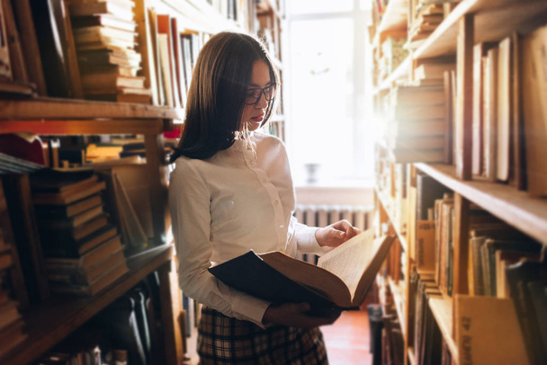 Девочка-подросток выбирает книги в библиотеке
 - Фото, изображение