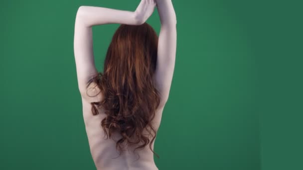長い髪のダンスと弾力的に動く赤毛の女性の背面図. - 映像、動画