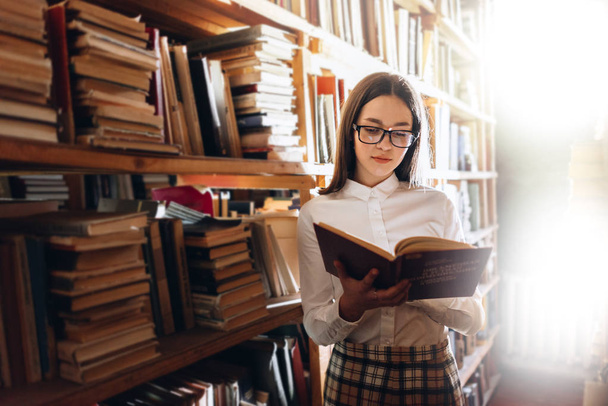 Adolescente menina escolher livros na biblioteca
 - Foto, Imagem