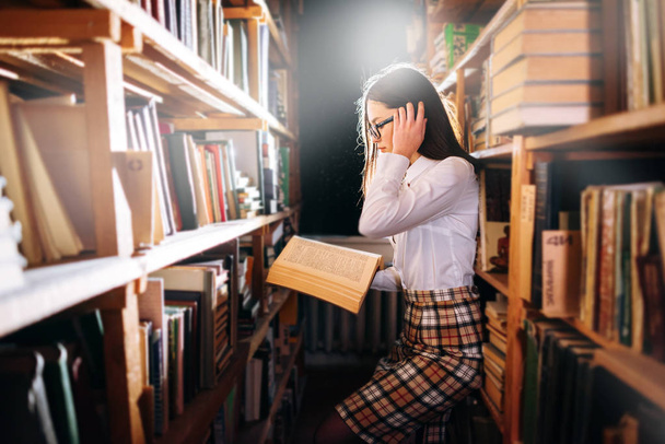Ragazza adolescente che sceglie libri in biblioteca
 - Foto, immagini