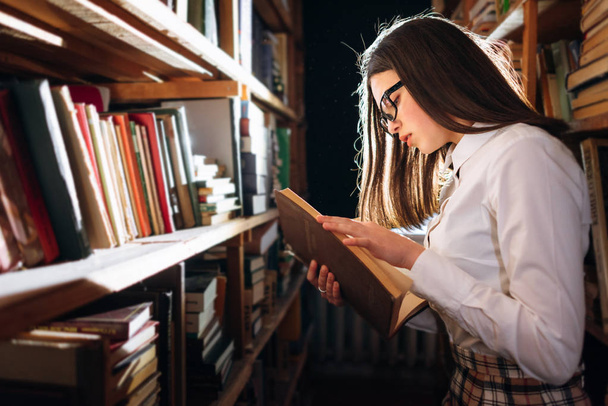 Adolescente chica elegir libros en la biblioteca
 - Foto, imagen