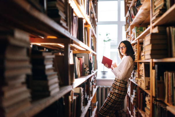 Adolescente chica elegir libros en la biblioteca
 - Foto, Imagen