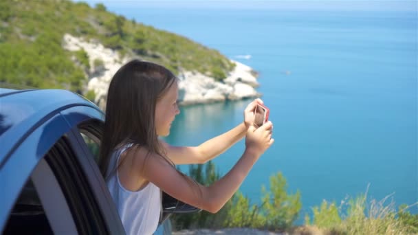 Μικρό κορίτσι σε διακοπές ταξίδι με το αυτοκίνητο. Καλοκαιρινές διακοπές και ταξίδια αυτοκίνητο έννοια - Πλάνα, βίντεο