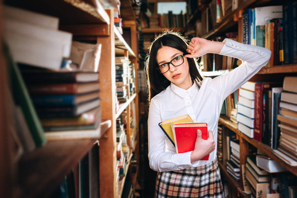 Carino adolescente in posa in biblioteca
 - Foto, immagini