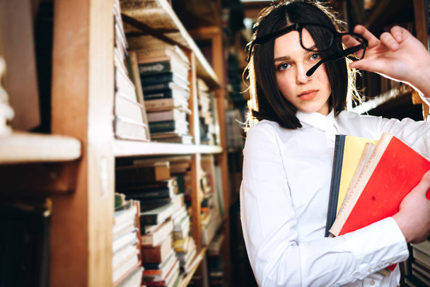 Cute teenage girl posing in library - Фото, изображение