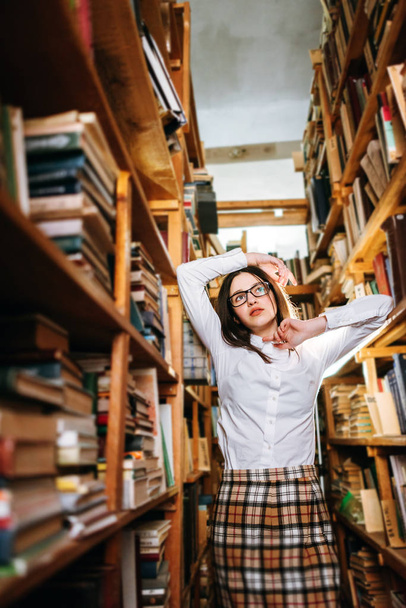 Linda adolescente posando en la biblioteca
 - Foto, Imagen