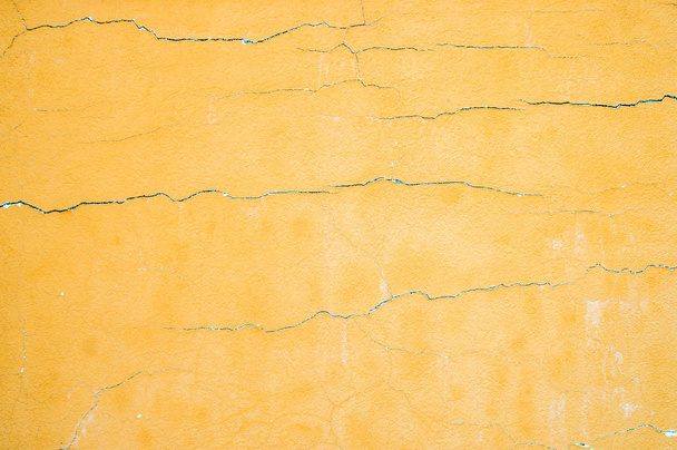                       De oude muur is bedekt met en geschilderd oranje is bedekt met scheuren          - Foto, afbeelding